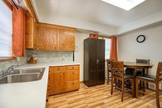 5041 Upton Ave N, Minneapolis, MN 55430 - kitchen with light wood-style flooring, tasteful backsplash, light countertops, and brown cabinetry