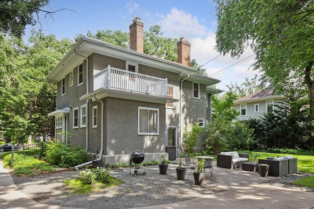 4626 Dupont Ave S, Minneapolis, MN 55419 - back of property featuring a balcony, outdoor lounge area, a chimney, stucco siding, and a patio