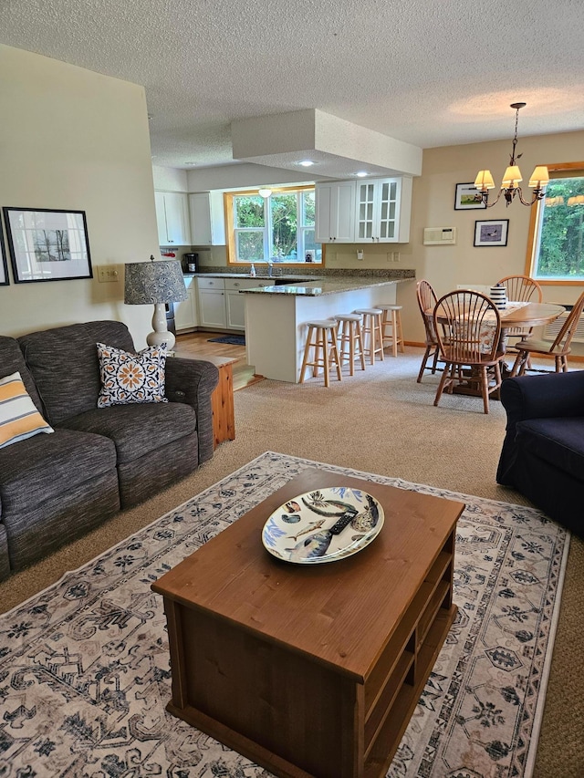 42674 305th Pl, Aitkin, MN 56431 - living area with a chandelier, a textured ceiling, and light colored carpet