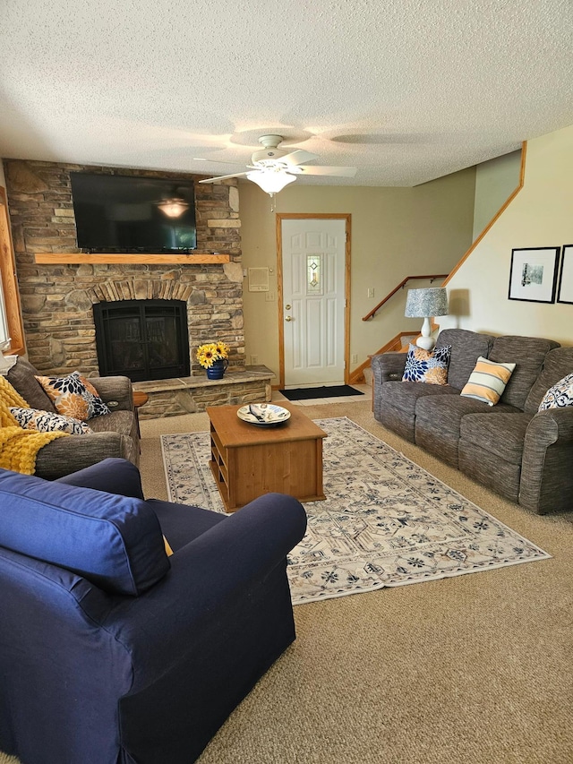 42674 305th Pl, Aitkin, MN 56431 - living area with carpet, a stone fireplace, a ceiling fan, a textured ceiling, and stairs