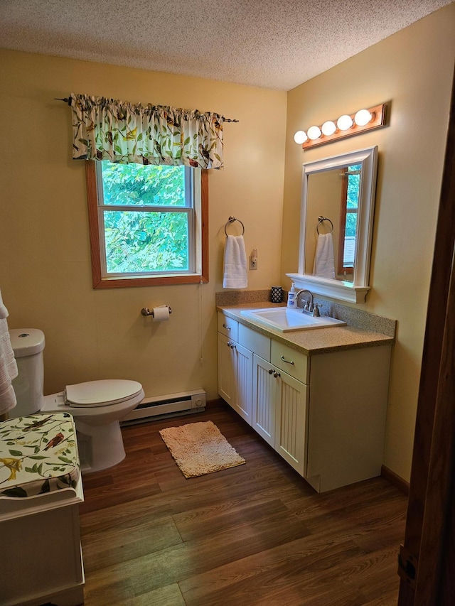 42674 305th Pl, Aitkin, MN 56431 - half bathroom featuring a baseboard heating unit, wood finished floors, vanity, and a textured ceiling