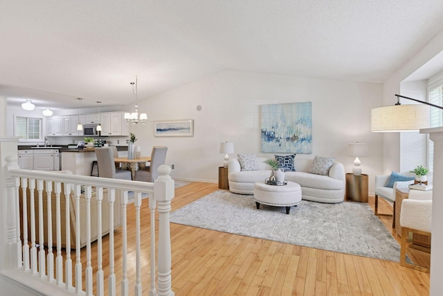 913 Carriage Ln, Chaska, MN 55318 - living area with light wood finished floors, vaulted ceiling, and a chandelier