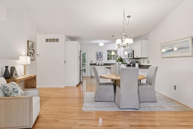 913 Carriage Ln, Chaska, MN 55318 - dining room with a chandelier and light wood-type flooring