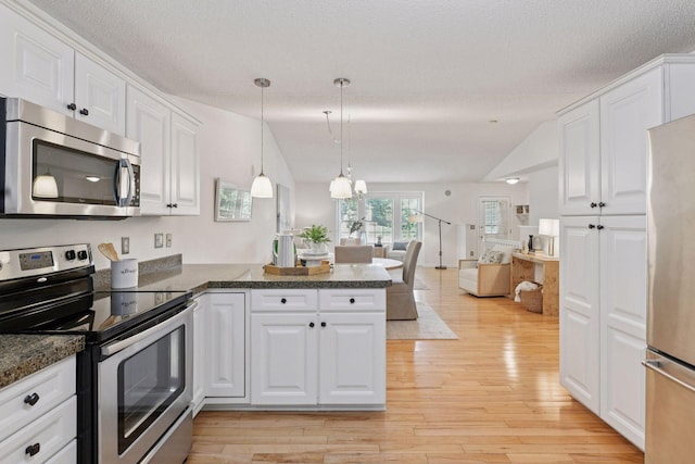 913 Carriage Ln, Chaska, MN 55318 - kitchen featuring appliances with stainless steel finishes, a peninsula, light wood finished floors, vaulted ceiling, and a textured ceiling