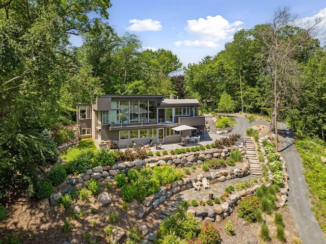 5962 Hobe Ln, White Bear Twp, MN 55110 - back of property featuring stairs, a patio area, a sunroom, and a view of trees