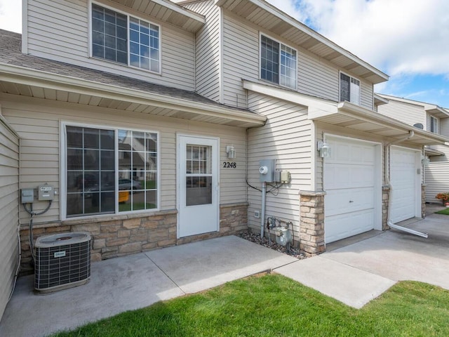 2248 Affirmed Dr, Shakopee, MN 55379 - property entrance featuring stone siding, an attached garage, and a shingled roof