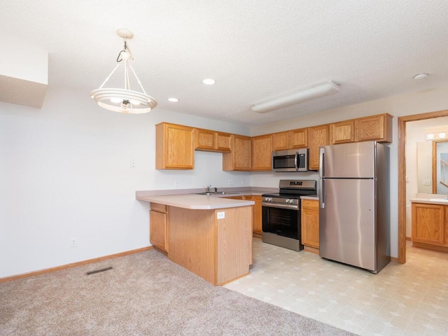 2248 Affirmed Dr, Shakopee, MN 55379 - kitchen featuring appliances with stainless steel finishes, a peninsula, light countertops, recessed lighting, and pendant lighting