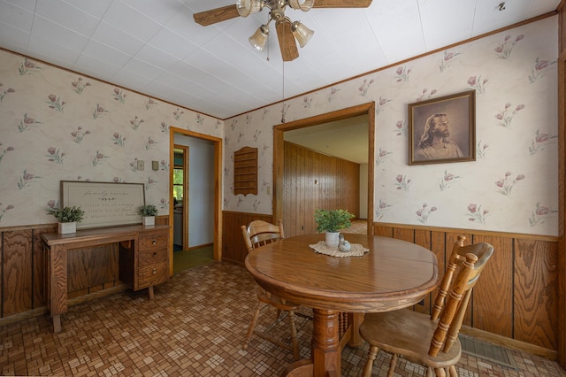 551 Edward Ln NE, Longville, MN 56655 - dining area featuring wallpapered walls, a wainscoted wall, a ceiling fan, wooden walls, and tile patterned floors