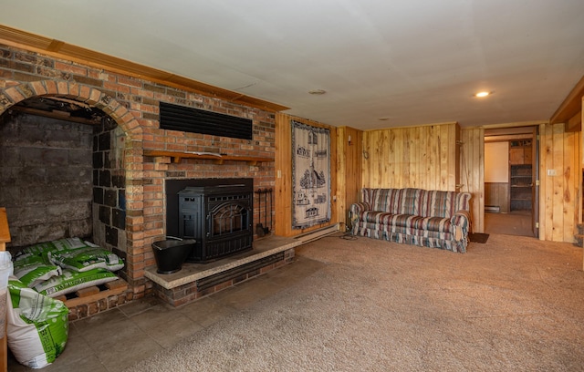 551 Edward Ln NE, Longville, MN 56655 - living area with a wood stove, wooden walls, a baseboard radiator, and carpet floors