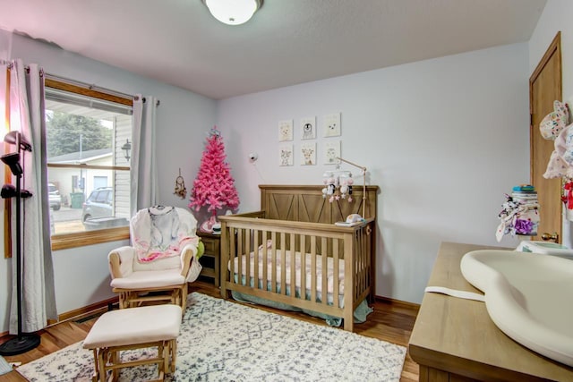 427 Alleghany Ave, Wabasha, MN 55981 - bedroom featuring a nursery area and wood finished floors