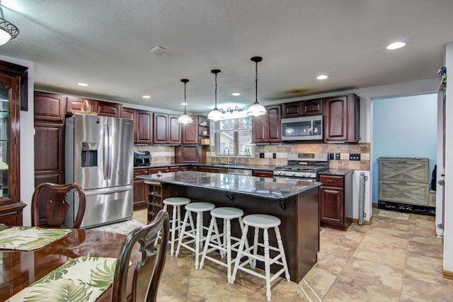427 Alleghany Ave, Wabasha, MN 55981 - kitchen with appliances with stainless steel finishes, a kitchen breakfast bar, a kitchen island, decorative backsplash, and recessed lighting