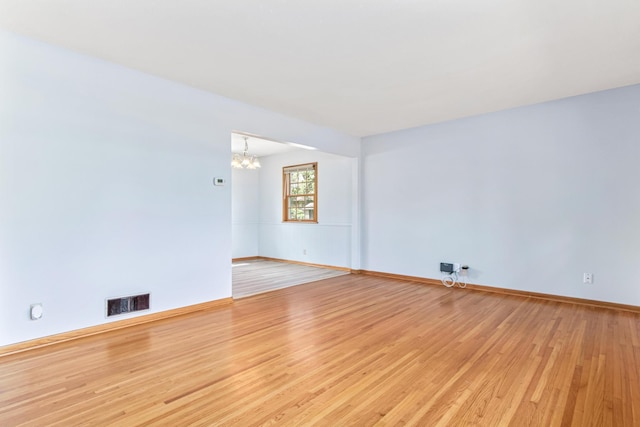 1920 108th Ln NW, Coon Rapids, MN 55433 - empty room featuring light wood-style flooring and a chandelier