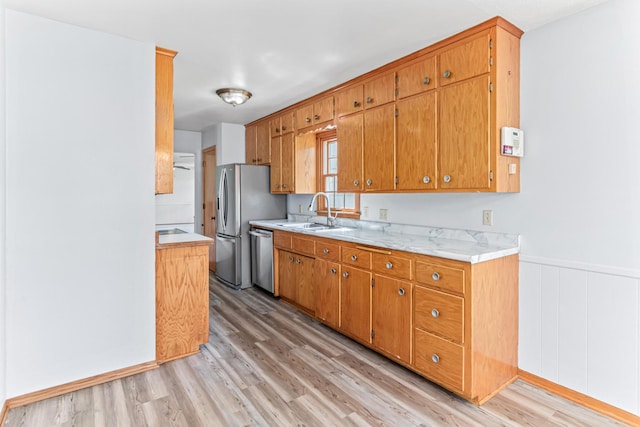 1920 108th Ln NW, Coon Rapids, MN 55433 - kitchen with appliances with stainless steel finishes, light wood-style flooring, light countertops, brown cabinetry, and wainscoting