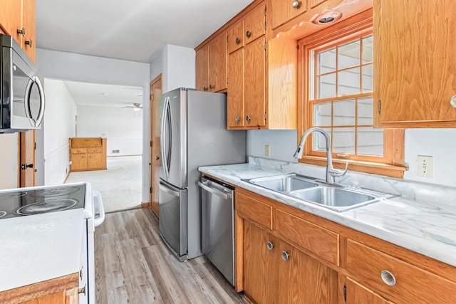 1920 108th Ln NW, Coon Rapids, MN 55433 - kitchen featuring stainless steel appliances, a ceiling fan, light wood-style flooring, light countertops, and brown cabinets