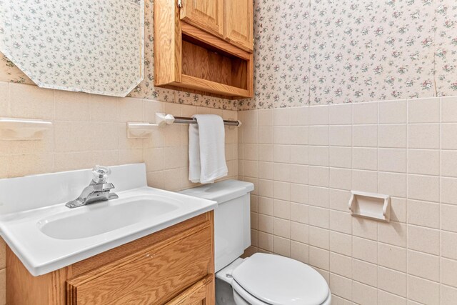 1920 108th Ln NW, Coon Rapids, MN 55433 - half bath with wallpapered walls, tile walls, vanity, and wainscoting