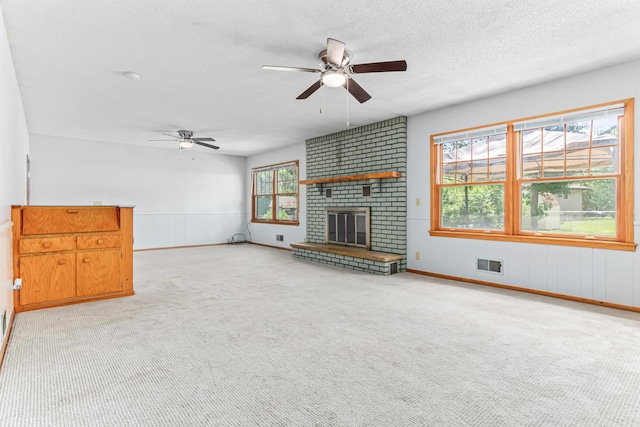 1920 108th Ln NW, Coon Rapids, MN 55433 - unfurnished living room featuring ceiling fan, carpet flooring, a textured ceiling, a fireplace, and wainscoting