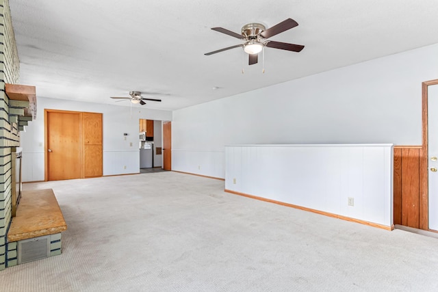 1920 108th Ln NW, Coon Rapids, MN 55433 - unfurnished living room featuring a ceiling fan, a brick fireplace, light colored carpet, and a wainscoted wall