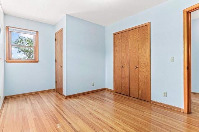 1920 108th Ln NW, Coon Rapids, MN 55433 - unfurnished bedroom with light wood-style floors and a closet