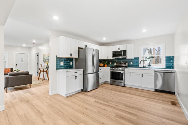 6821 225th Ln N, Stacy, MN 55079 - kitchen featuring stainless steel appliances, decorative backsplash, light countertops, light wood-type flooring, and recessed lighting