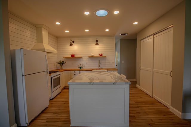 850 60th Ave SW, Benson, MN 56231 - kitchen with white appliances, custom exhaust hood, wood finished floors, recessed lighting, and white cabinetry