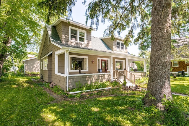 4223 Mcculloch St, Duluth, MN 55804 - bungalow featuring covered porch, roof with shingles, and a front lawn