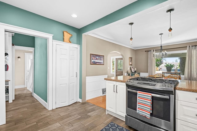 4223 Mcculloch St, Duluth, MN 55804 - kitchen with stainless steel gas stove, white cabinetry, arched walkways, a chandelier, and recessed lighting
