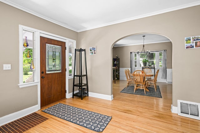 4223 Mcculloch St, Duluth, MN 55804 - entrance foyer with arched walkways, a chandelier, wood finished floors, and crown molding