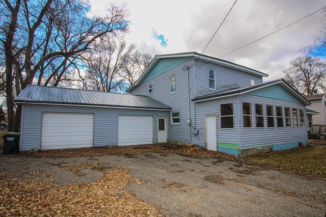 608 Lake St, Osakis, MN 56360 - view of home's exterior featuring a metal roof, asphalt driveway, a garage, and a sunroom