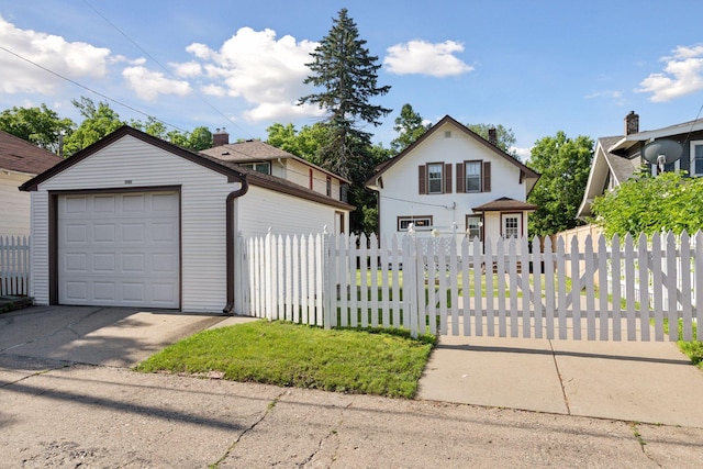 2085 Princeton Ave, Saint Paul, MN 55105 - traditional-style home with an outbuilding, a fenced front yard, concrete driveway, and a detached garage