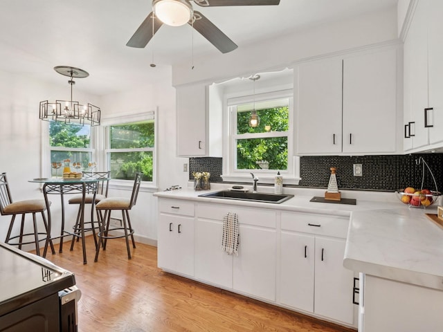 910 62nd St, Minneapolis, MN 55419 - kitchen featuring backsplash, white cabinets, light countertops, and light wood-type flooring
