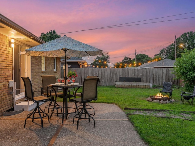 910 62nd St, Minneapolis, MN 55419 - patio terrace at dusk featuring an outdoor fire pit, a fenced backyard, and a patio area