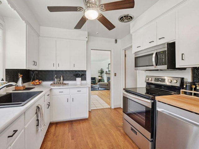 910 62nd St, Minneapolis, MN 55419 - kitchen with stainless steel appliances, light wood finished floors, light countertops, backsplash, and ceiling fan