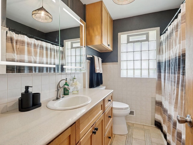 910 62nd St, Minneapolis, MN 55419 - bathroom featuring vanity, tile walls, and tile patterned flooring