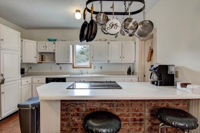 924 6th St W, Wabasha, MN 55981 - kitchen with a peninsula, white cabinetry, black appliances, and light countertops