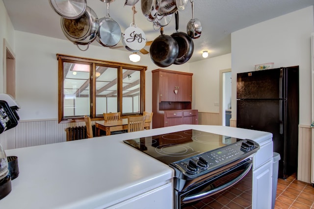 924 6th St W, Wabasha, MN 55981 - kitchen with black appliances, wainscoting, light tile patterned floors, and light countertops