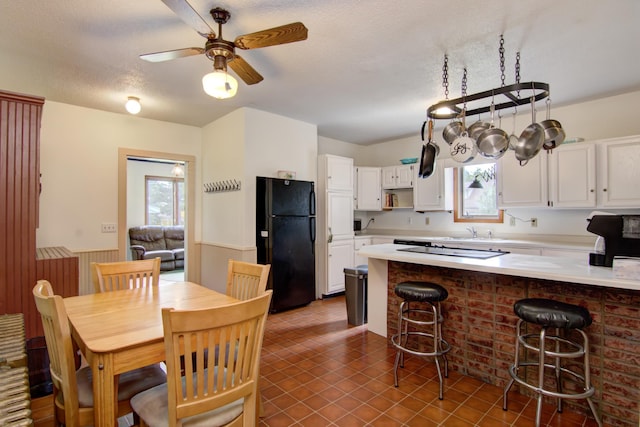 924 6th St W, Wabasha, MN 55981 - kitchen featuring black appliances, white cabinets, a peninsula, light countertops, and wainscoting
