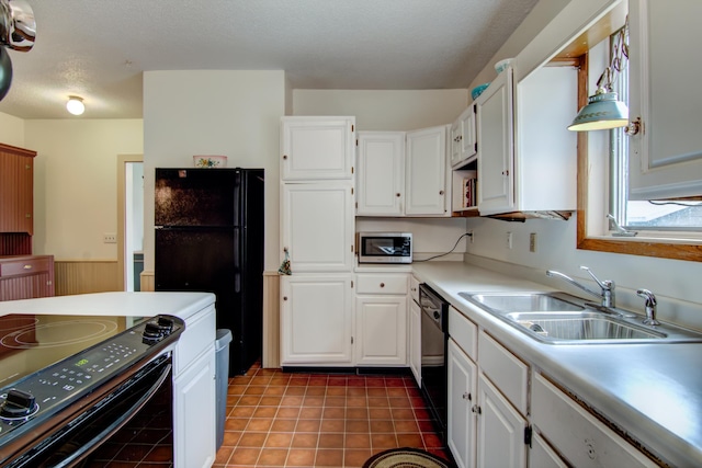 924 6th St W, Wabasha, MN 55981 - kitchen featuring black appliances, white cabinets, light countertops, tile patterned floors, and wainscoting