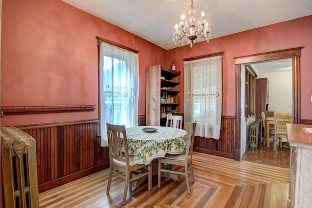 924 6th St W, Wabasha, MN 55981 - dining space featuring a chandelier, radiator heating unit, a wainscoted wall, and a textured ceiling