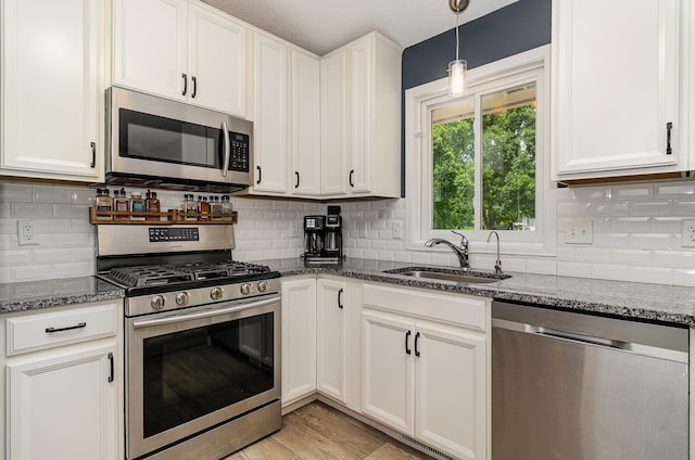 5750 Lone Oak Dr, Savage, MN 55378 - kitchen with appliances with stainless steel finishes, dark stone countertops, white cabinets, and tasteful backsplash