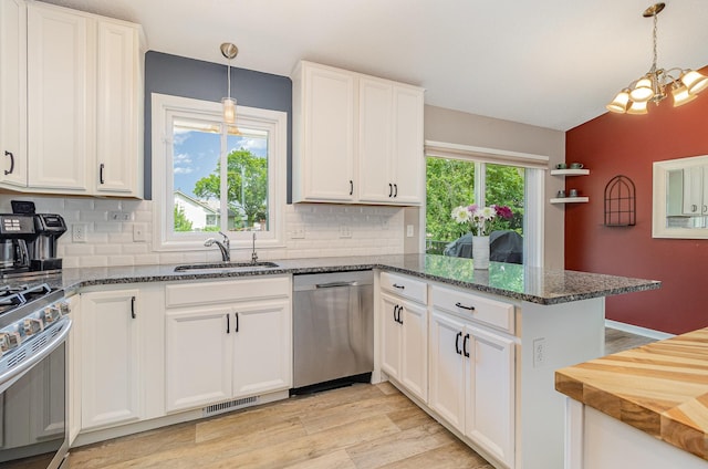 5750 Lone Oak Dr, Savage, MN 55378 - kitchen featuring appliances with stainless steel finishes, a peninsula, backsplash, white cabinets, and light wood-type flooring