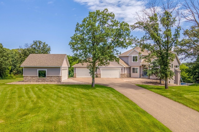 141 145th Ln NE, Ham Lake, MN 55304 - view of front of house with stone siding, a front lawn, concrete driveway, and an attached garage