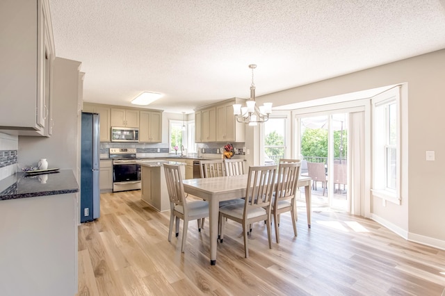 141 145th Ln NE, Ham Lake, MN 55304 - dining room featuring light wood finished floors, a textured ceiling, and a chandelier