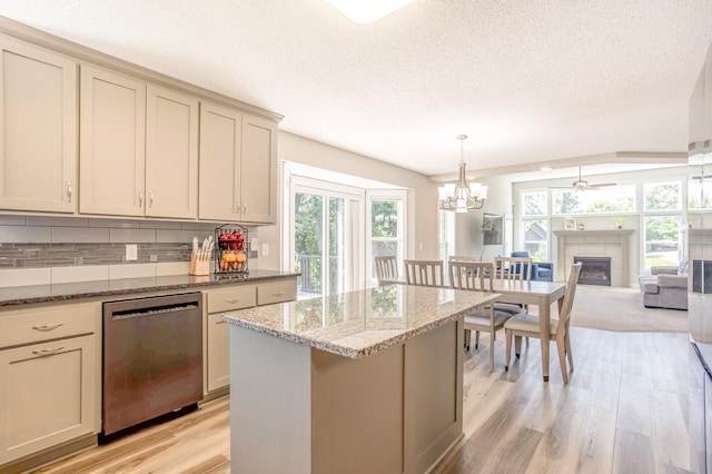 141 145th Ln NE, Ham Lake, MN 55304 - kitchen featuring dishwasher, light wood finished floors, decorative backsplash, a textured ceiling, and a glass covered fireplace