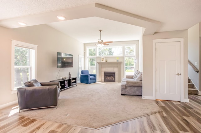 141 145th Ln NE, Ham Lake, MN 55304 - living area with wood finished floors, a ceiling fan, a tiled fireplace, and stairway