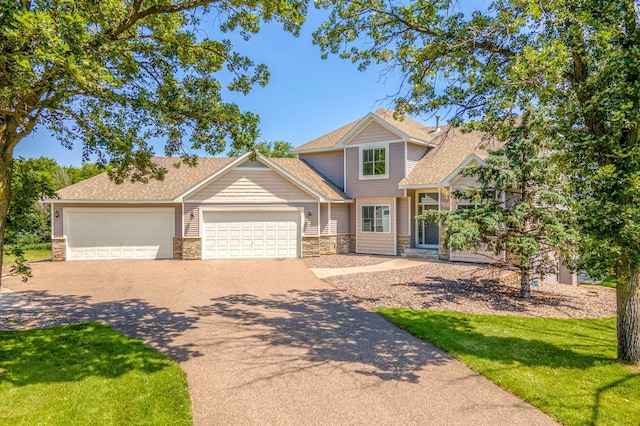 141 145th Ln NE, Ham Lake, MN 55304 - craftsman inspired home featuring stone siding, concrete driveway, an attached garage, a front lawn, and roof with shingles