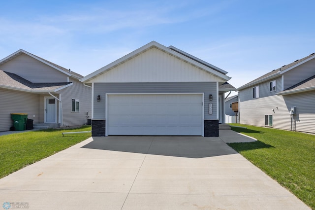 1009 Highland Ln W, West Fargo, ND 58078 - view of front of house featuring a front lawn, stone siding, driveway, and an attached garage
