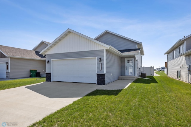 1009 Highland Ln W, West Fargo, ND 58078 - view of front of home with a garage, concrete driveway, a front yard, stone siding, and board and batten siding