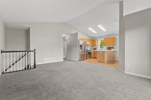 6913 174th St W, Farmington, MN 55024 - kitchen featuring appliances with stainless steel finishes, light colored carpet, open floor plan, vaulted ceiling, and light countertops