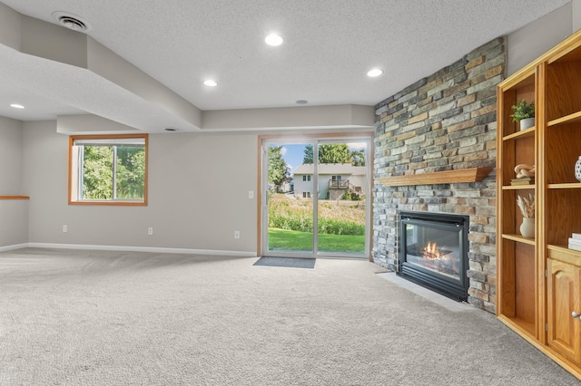 6913 174th St W, Farmington, MN 55024 - unfurnished living room featuring a textured ceiling, carpet floors, a large fireplace, plenty of natural light, and recessed lighting