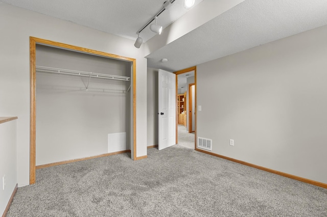 6913 174th St W, Farmington, MN 55024 - unfurnished bedroom with carpet flooring, a closet, a textured ceiling, and track lighting